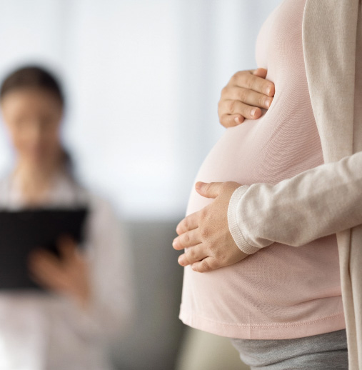 Pregnant woman in a doctor's office with her hand on her belly