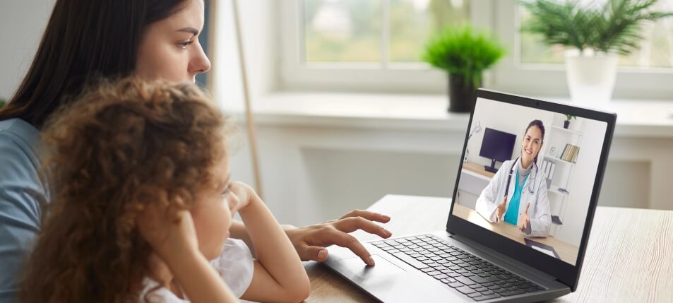 Woman and young daughter using telehealth services from their laptop